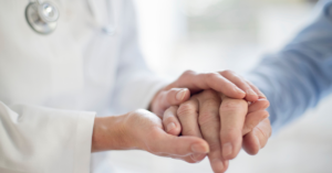 GP holding patients hand