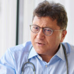 A male general practitioner speaks with a patient about lung cancer screen